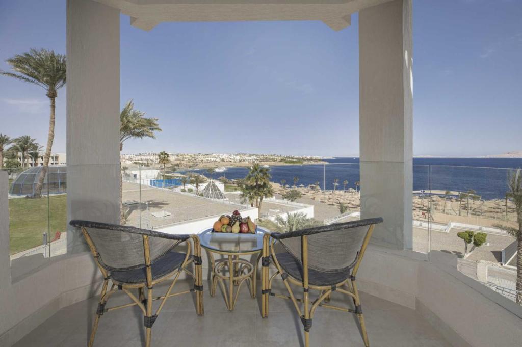 a table and chairs on a balcony with a view of the ocean at V Hotel Sharm El Shiekh in Sharm El Sheikh