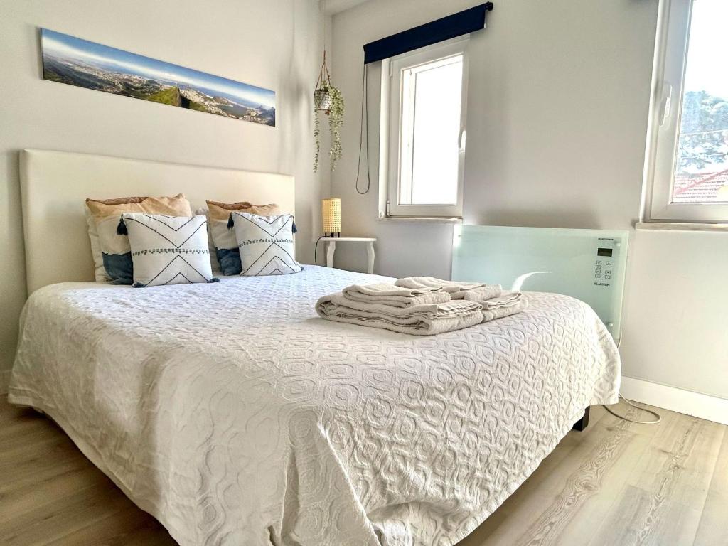 a bedroom with a bed with white sheets and pillows at Studio Polvo in Parede