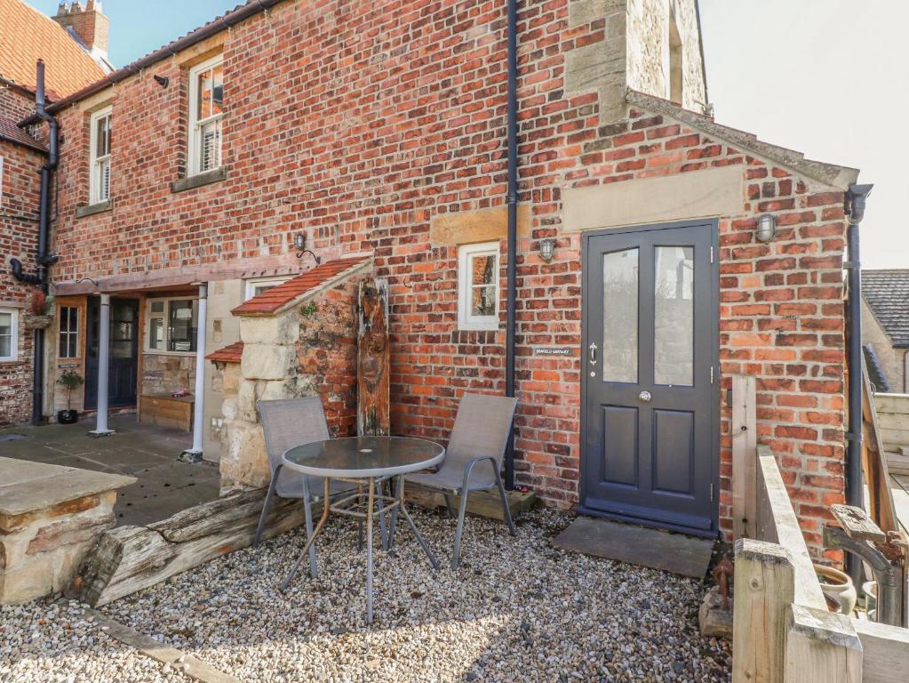 a table and chairs in front of a brick building at Seafield Granary in Alnwick