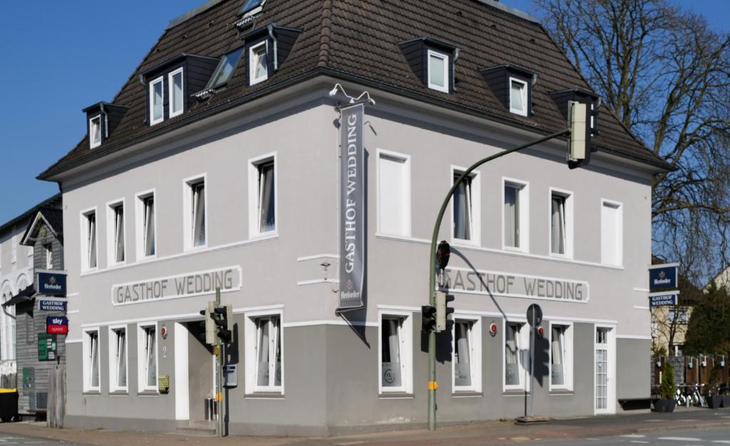 a large white building with a black roof at Gasthof Wedding in Bielefeld