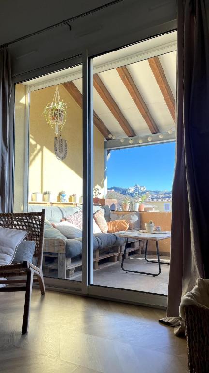 d'un salon avec une porte coulissante en verre s'ouvrant sur une terrasse. dans l'établissement Duplex avec vue sur les Alpilles, à Saint-Rémy-de-Provence
