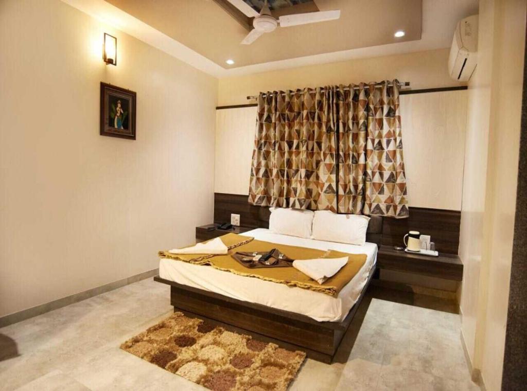 a bedroom with a bed and a window at Hotel Sai Suraj Park in Shirdi