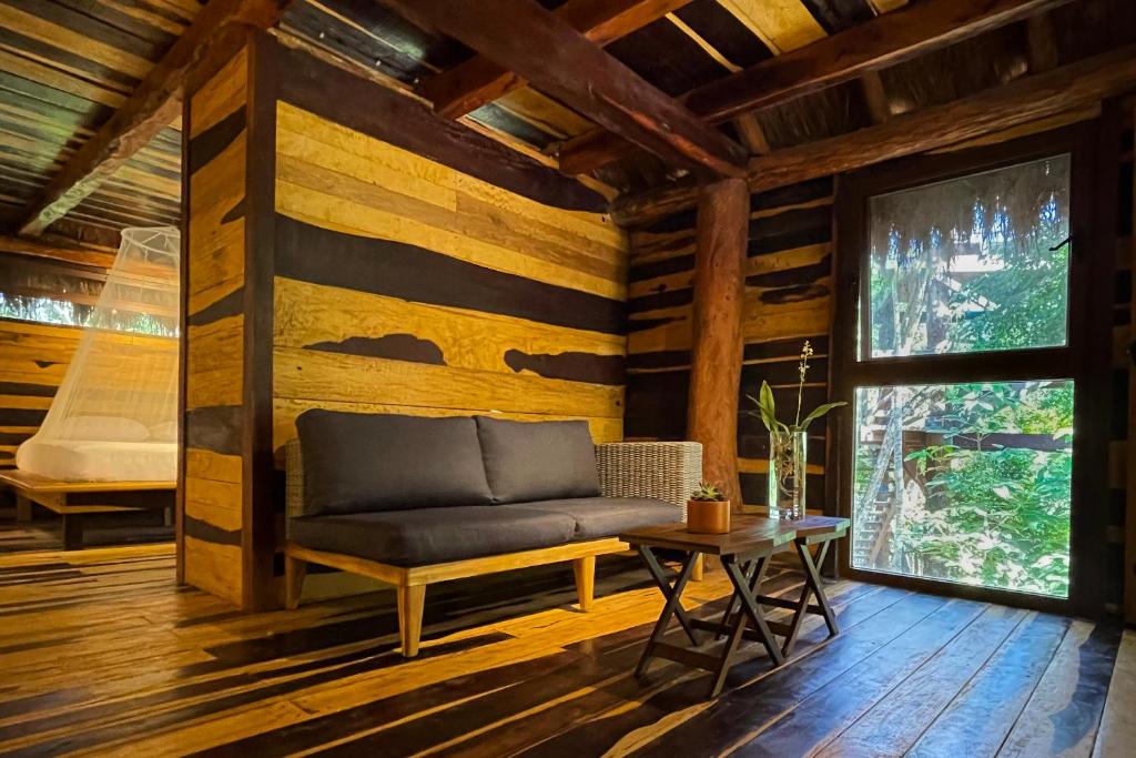 een woonkamer met een bank en een tafel bij Treehouse Tulum H2Ojos in Tulum