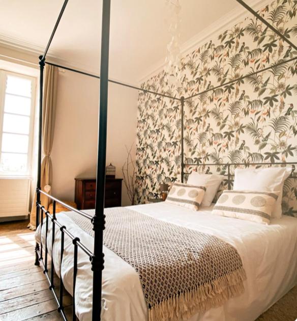 - une chambre avec un lit à baldaquin et un papier peint floral dans l'établissement Jolly Château - private room 