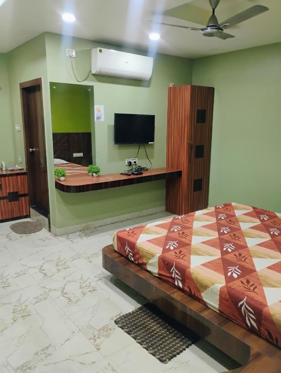 una camera con letto e TV a parete di Umas Regency a Guwahati