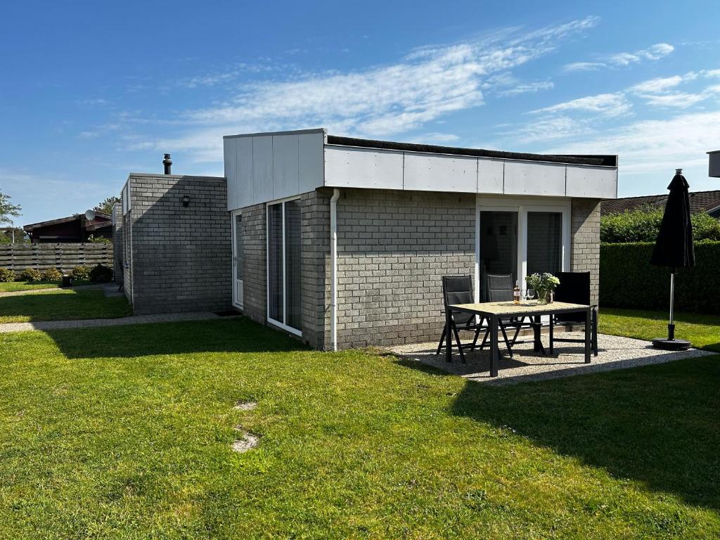 ユリアーナドルプにあるBungalow Noordzee Dの庭の小さなレンガ造りの家