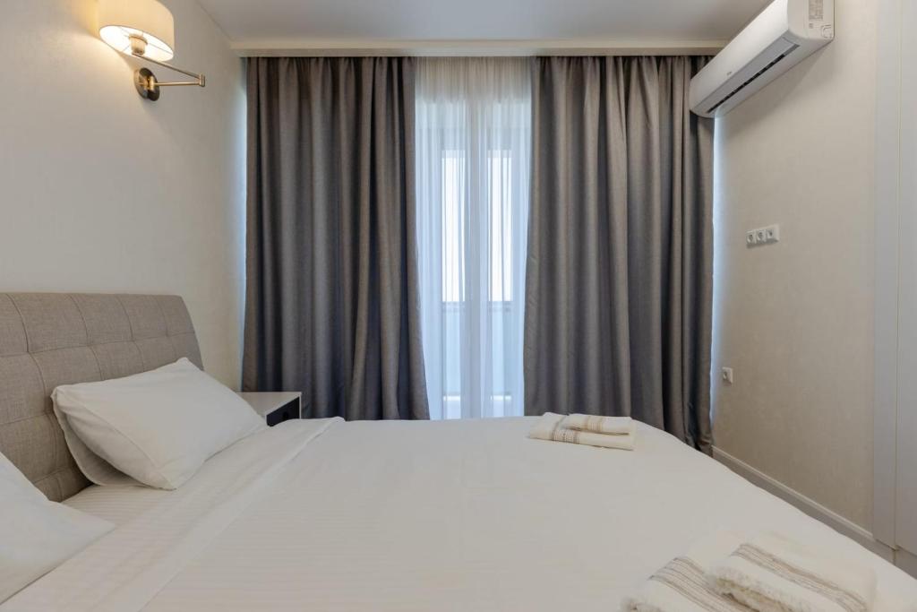 a bedroom with a large white bed and a window at Batum World 2014 in Batumi