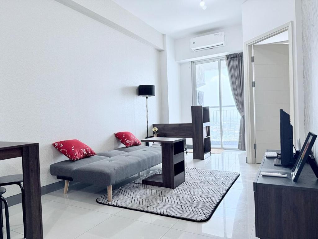 スラバヤにあるBenson 2 BR & 1 Pakuwon mall for 5 peoples stayのソファとテレビのあるリビングルーム