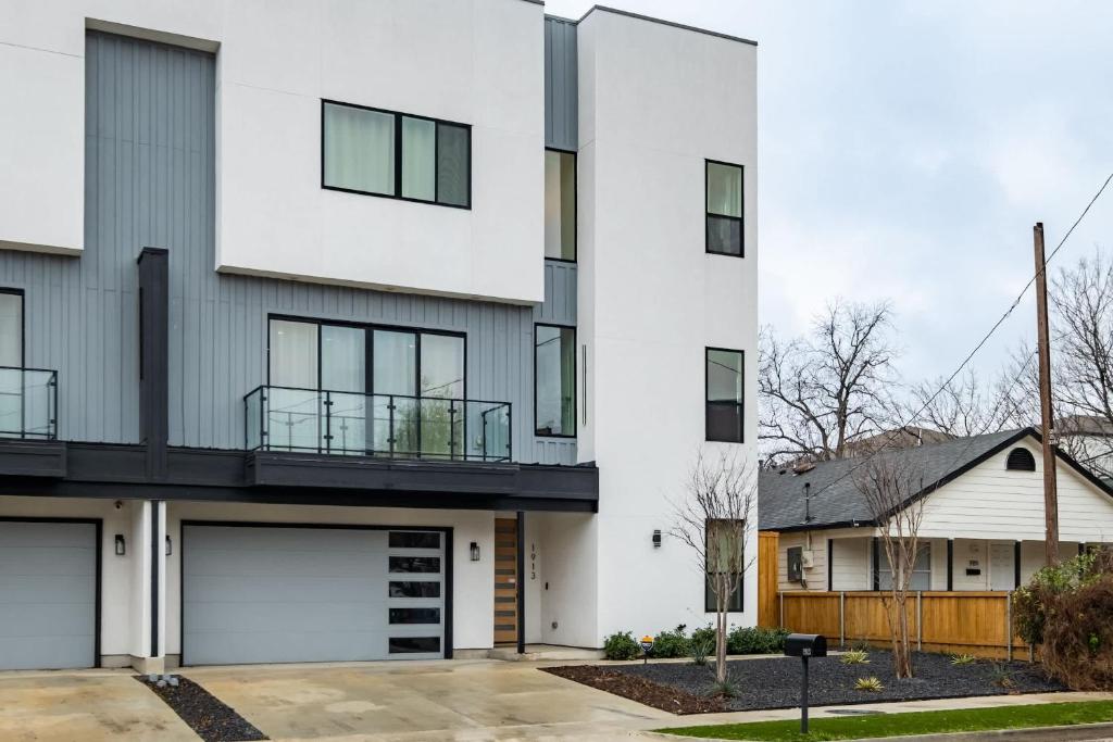 un edificio blanco con dos puertas de garaje en Luxury 4BR Townhouse with Rooftop Patio and BBQ, en Dallas