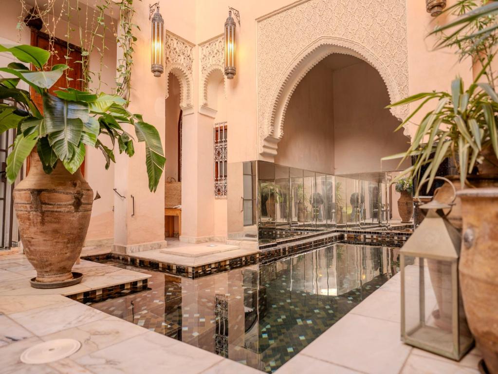une piscine intérieure dans un bâtiment avec des plantes dans l'établissement Riad Mayan & Spa, à Marrakech