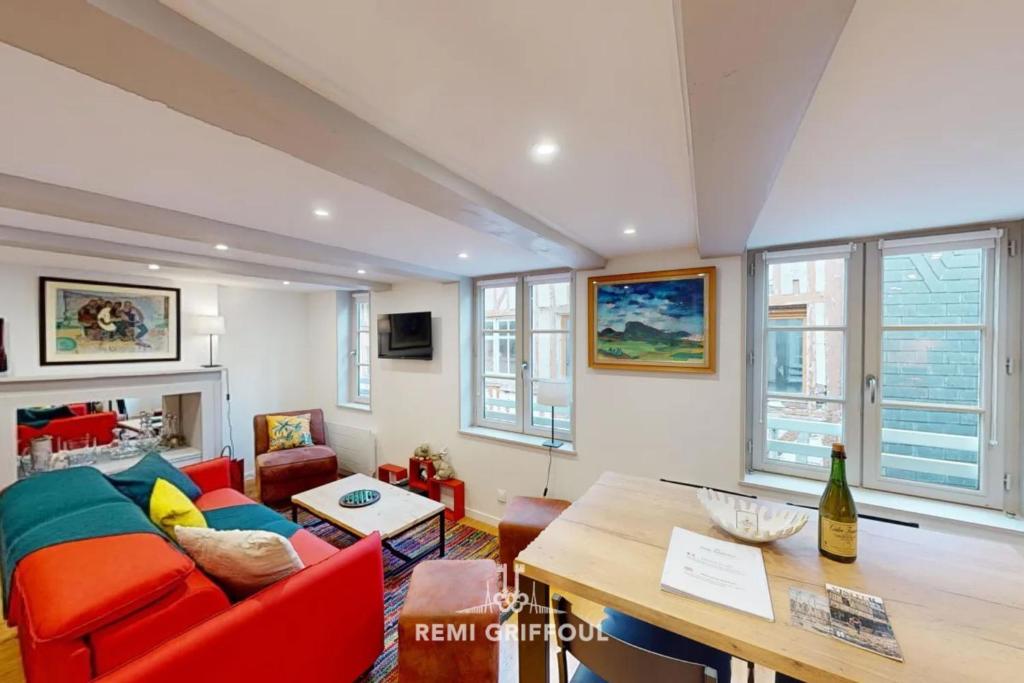 un salon avec un canapé rouge et une table dans l'établissement Le Repère de Popeye Beautiful Apartment Honfleur 4 Guests, à Honfleur