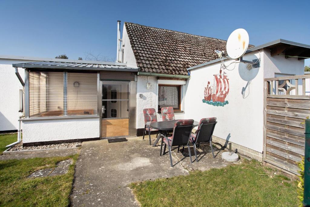 une table et des chaises devant une maison dans l'établissement Ferienhaus Am Darß - Kogge, à Pruchten