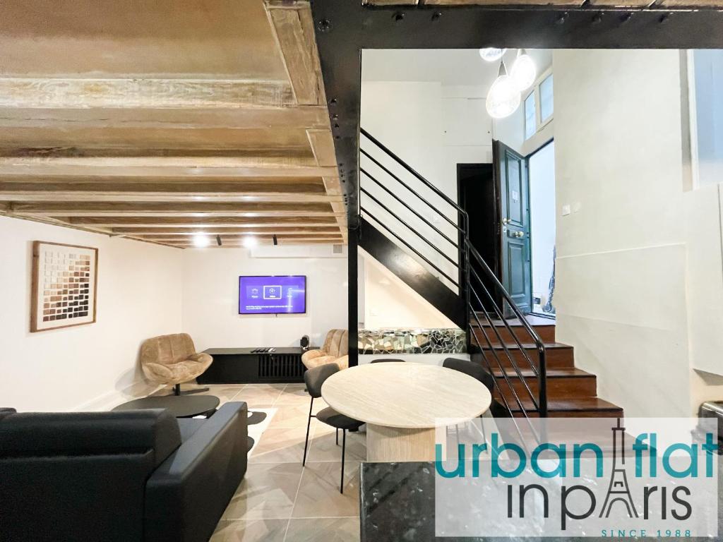 un salon avec une table et des chaises et un escalier dans l'établissement Urban Flat 09 - Stylish Triplex Champs-Elysees, à Paris