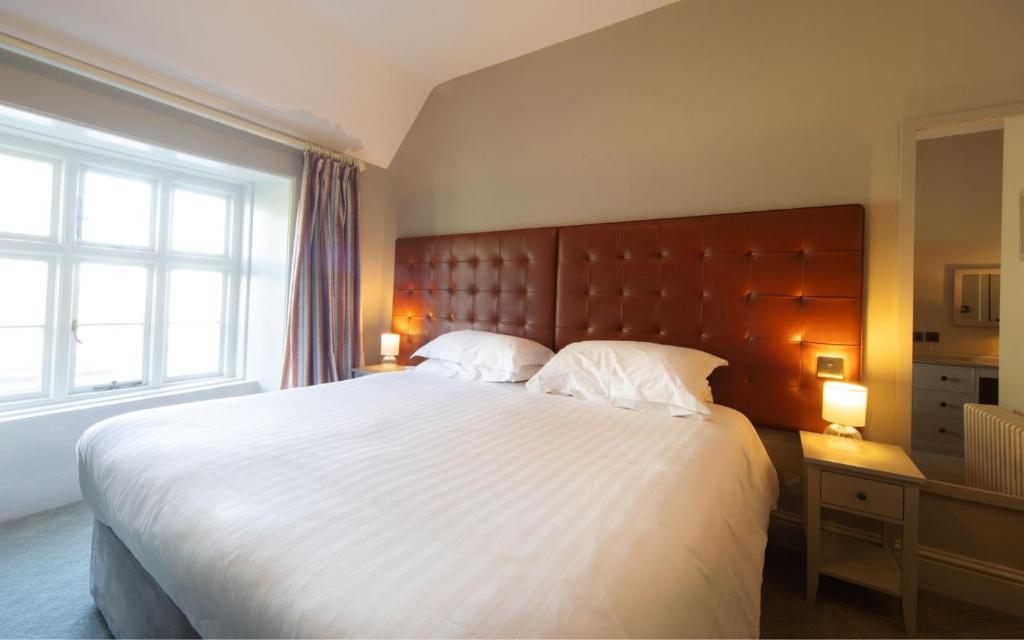 a bedroom with a large bed and a large window at Heacham Manor Hotel in Hunstanton