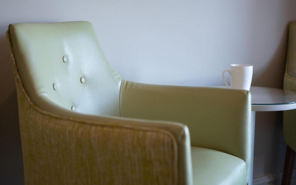 a chair in a room with a table at Heacham Manor Hotel in Hunstanton