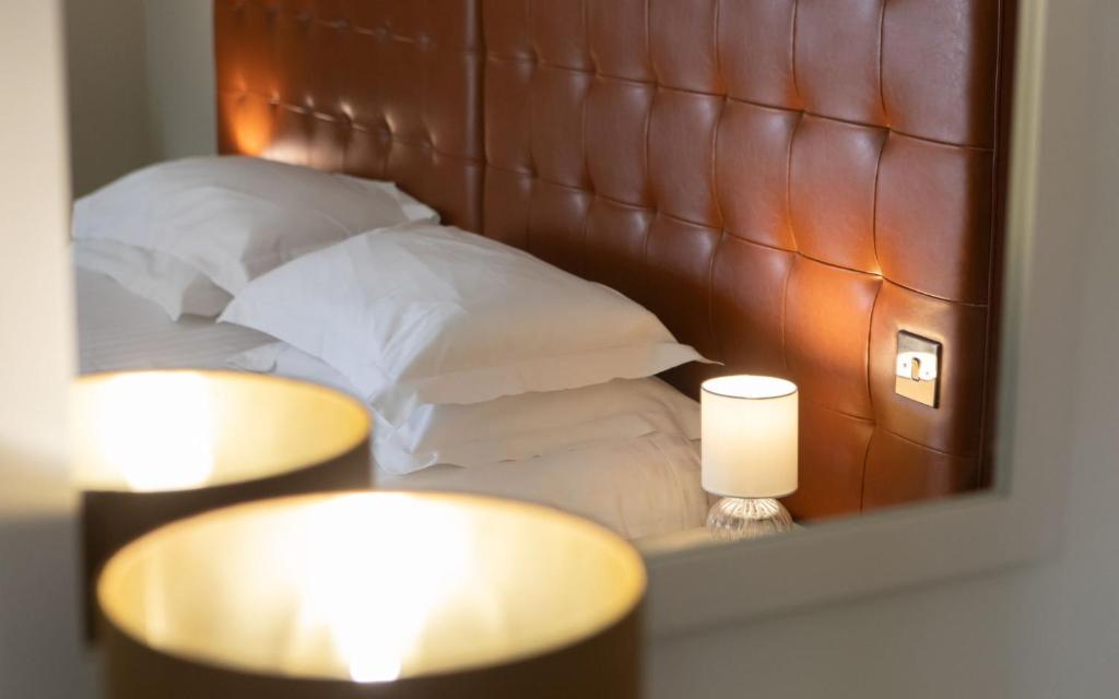 a reflection of a bed with pillows in a mirror at Heacham Manor Hotel in Hunstanton