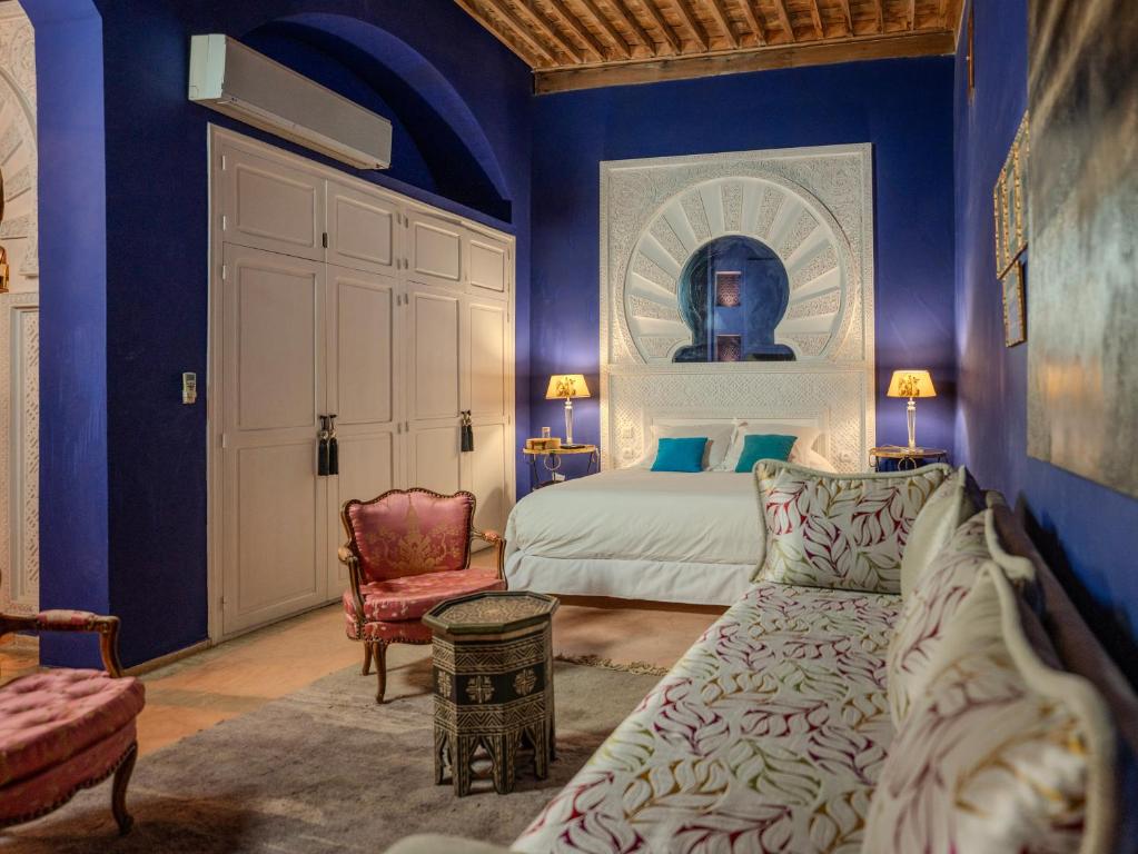 - une chambre avec des murs bleus, un lit et un canapé dans l'établissement Riad Mayan & Spa, à Marrakech 90 autres photos