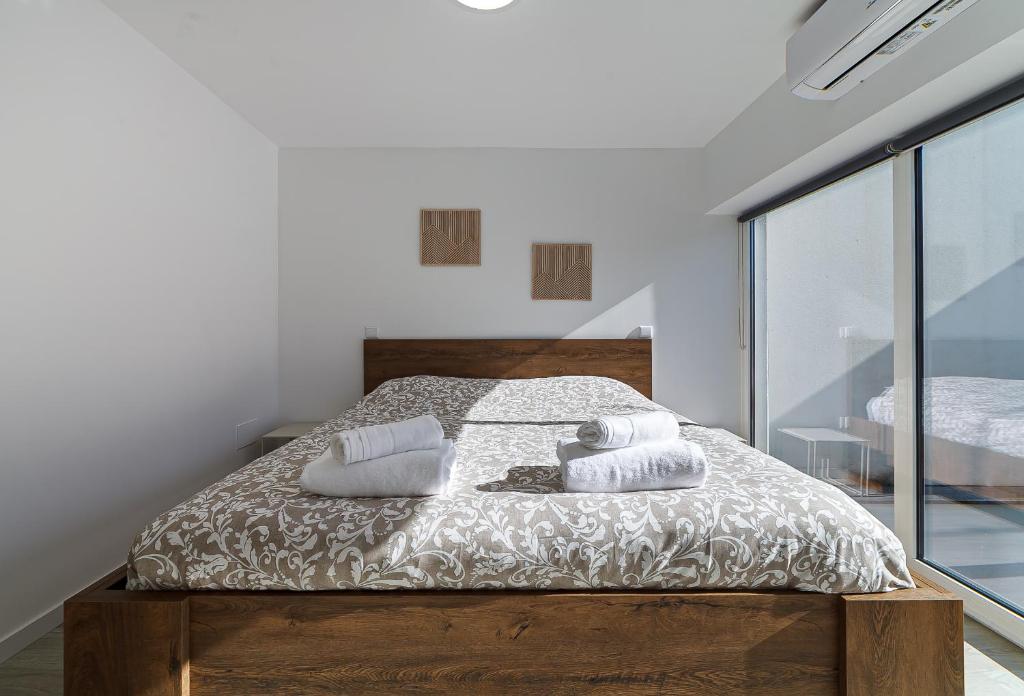 ein Schlafzimmer mit einem Bett mit zwei Kissen darauf in der Unterkunft Casinha da Rita by Home Sweet Home Aveiro in Aveiro