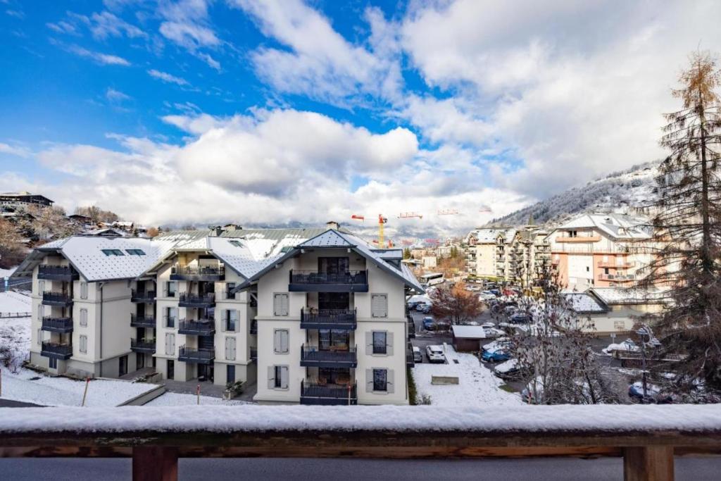 - un balcon offrant une vue sur un bâtiment dans la neige dans l'établissement T3 chalet with terrace at the foot of the slopes, à Saint-Gervais-les-Bains