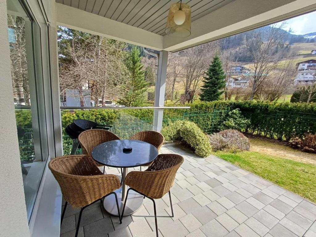 - werandę ze stołem i krzesłami w obiekcie Falcon Lodge Kaprun Kitzsteinhorn - Steinbock Lodges w Kaprunie