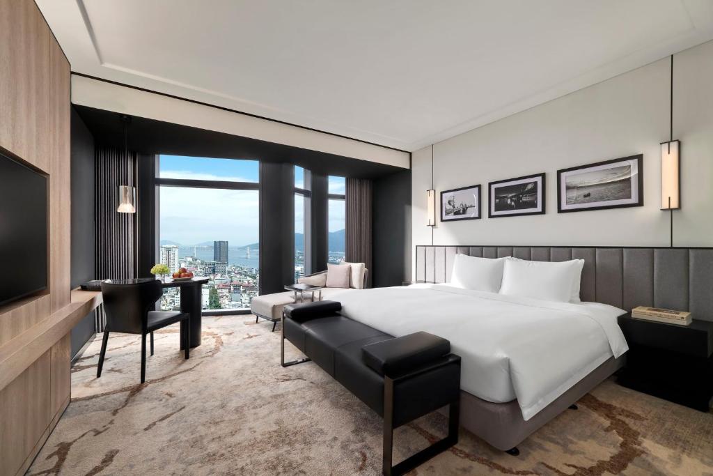 ダナンにあるCrowne Plaza Danang City Centre by IHGの大きなベッドと机があるホテルの部屋