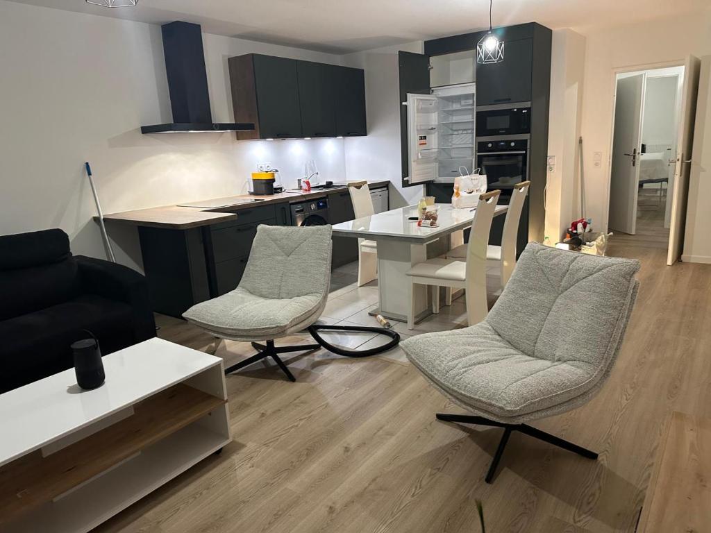 une cuisine et un salon avec une table et des chaises dans l'établissement Colombes - Logement entier 2 chambres - Salon, à Colombes