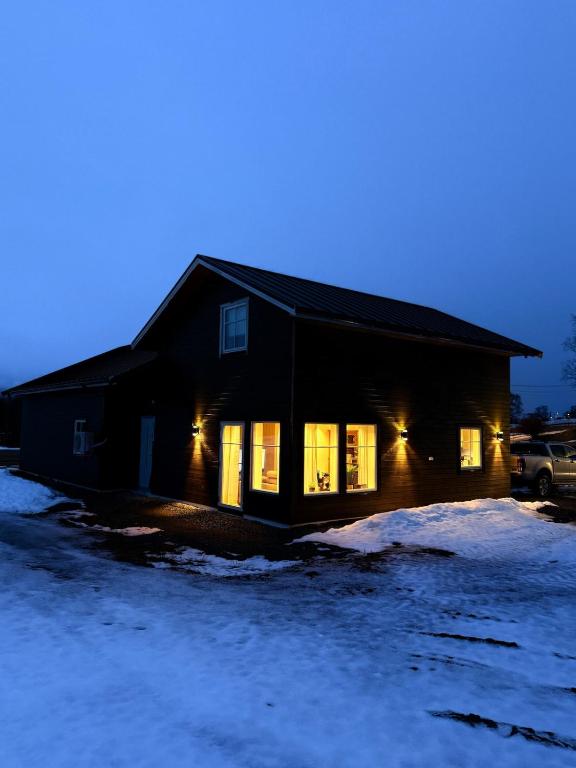 a house with its lights on in the snow at Bella Karnes in Oksevik