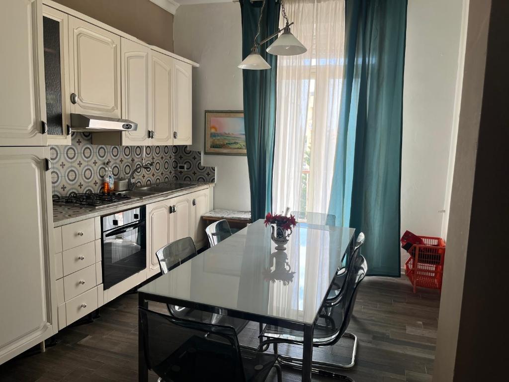 cocina con mesa con sillas y ventana en Al Numero175, en Agrigento
