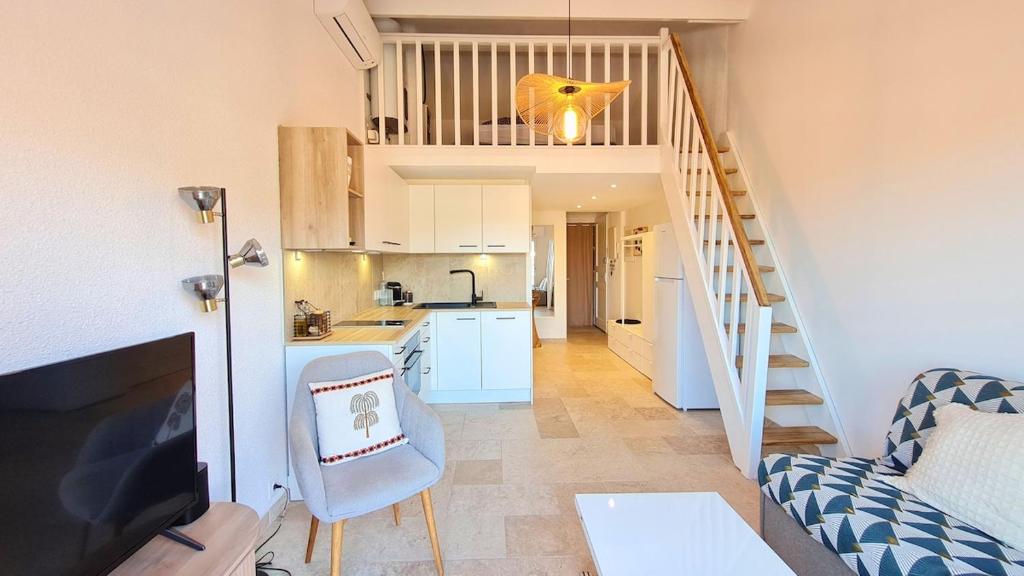 une cuisine et un salon avec un escalier dans une maison dans l'établissement Apartbleuazur - Bel appartement rénové piscine & vue mer, à Cavalaire-sur-Mer