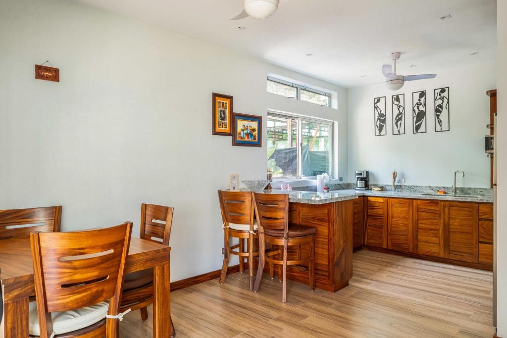a kitchen with wooden cabinets and a table and chairs at Casa Lapas in Uvita