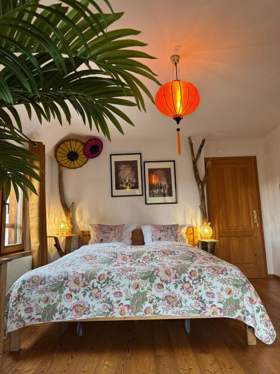 - une chambre avec un grand lit et une grande plante dans l'établissement Gîte au Manoir des Sens - Escapade insolite aux parfums et couleurs d Asie, à Bergheim