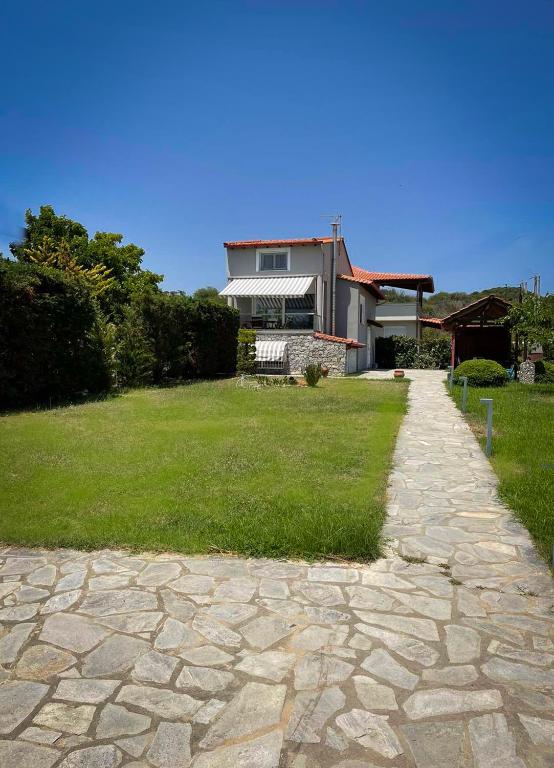 a house with a stone path in front of a yard at Only Blue Villa in Karianí