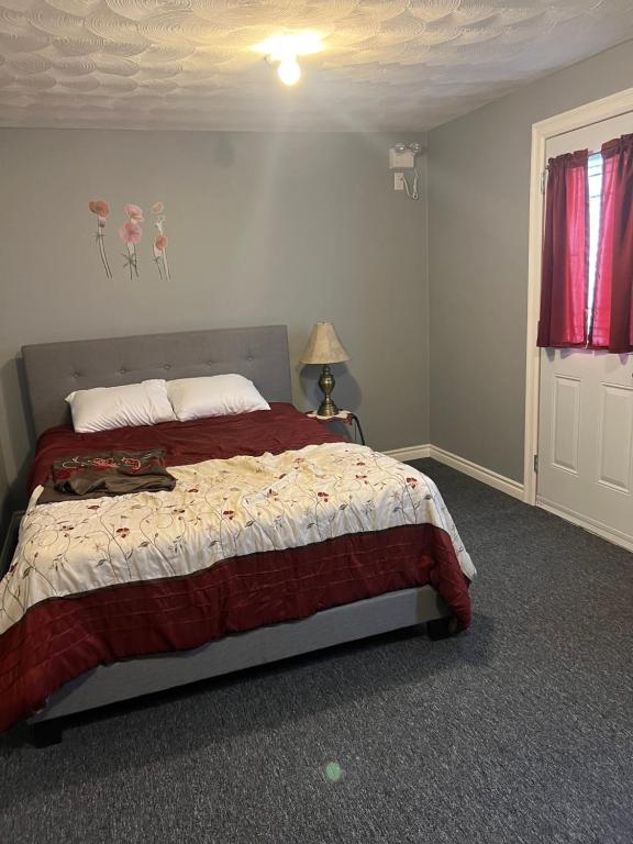 ein Schlafzimmer mit einem Bett mit roter Bettdecke in der Unterkunft Hillside View in Burlington