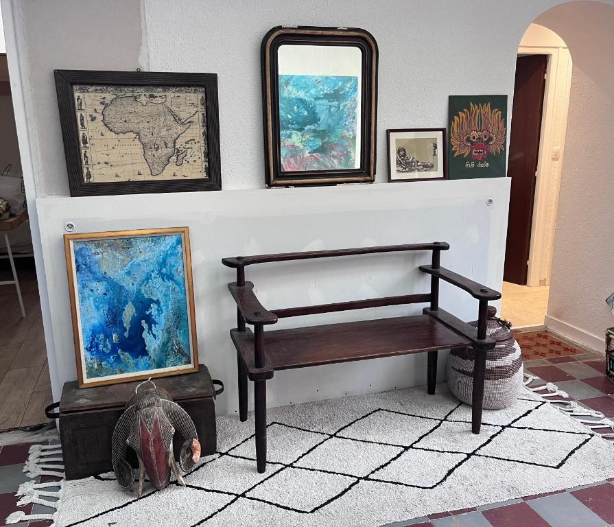 une pièce avec un banc et des tableaux sur un mur dans l'établissement Villa Ma-Oé, à L'Aiguillon-la-Presqu'île
