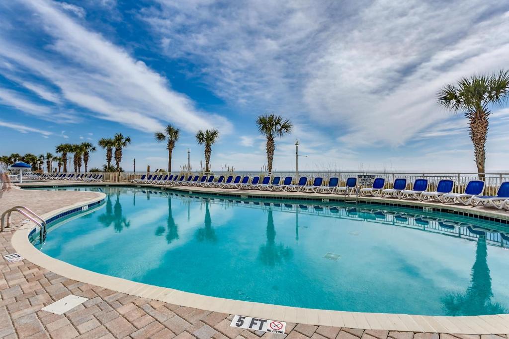 a large swimming pool with palm trees and chairs at Oceanfront TOP LOCATION MODERN RESORT Lazy River Huge Pool Oasis in Myrtle Beach
