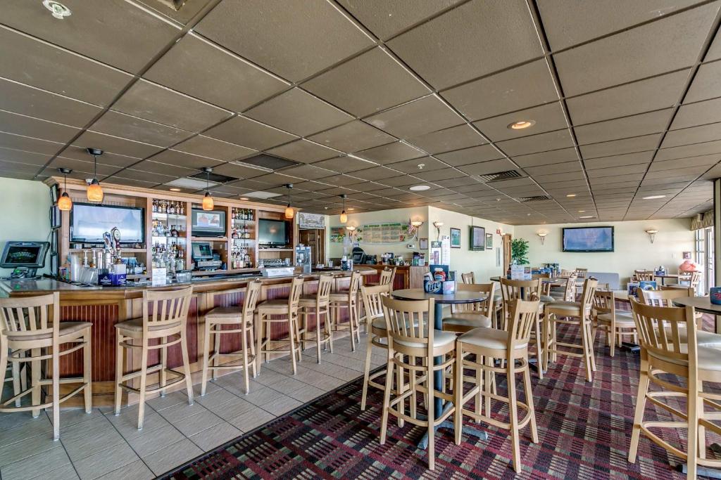 a restaurant with tables and chairs and a bar at Oceanfront TOP LOCATION MODERN RESORT Lazy River Huge Pool Oasis in Myrtle Beach