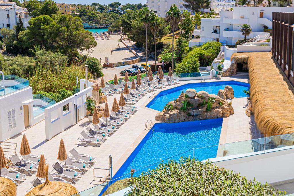 an aerial view of a resort pool with chairs and umbrellas at MarSenses Ferrera Blanca Hotel - Adults Only in Cala d´Or