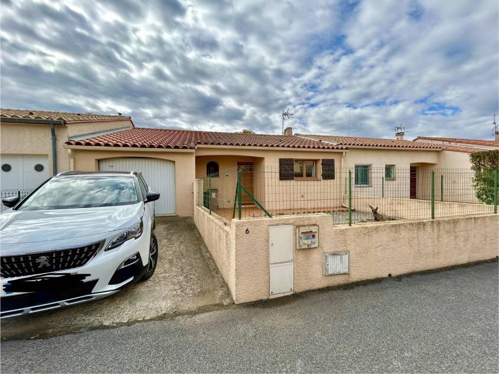 une voiture blanche garée devant une maison dans l'établissement Charmante villa 4 pers avec jardin, garage, TV et cuisine équipée - Argelès Village - FR-1-388-174, à Argelès-sur-Mer