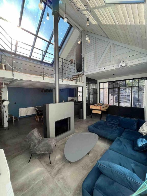 un salon avec un canapé bleu et une cheminée dans l'établissement Restored loft in Trouville, à Trouville-sur-Mer