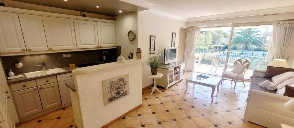 une cuisine et un salon avec un canapé et une table dans l'établissement Superb Apt Great Comfort with Balcony & Pool, à Sainte-Maxime
