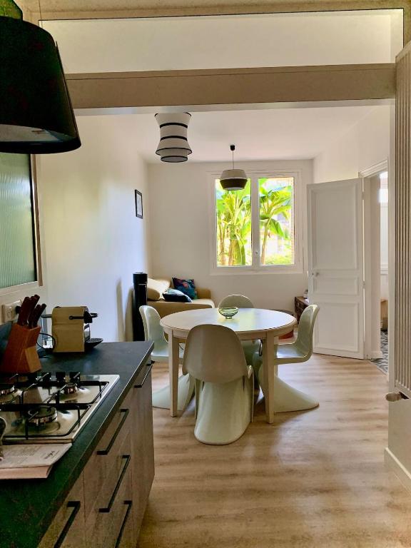 une cuisine et un salon avec une table et des chaises dans l'établissement Ô ma belle demeure - Parking Privé, à Aix-les-Bains