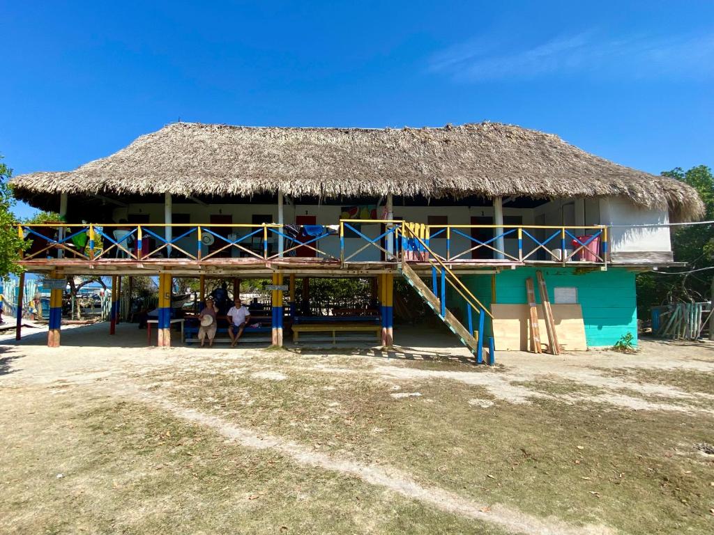 un grand bâtiment avec un toit de chaume dans l'établissement Hostal Doña Aura, à Tintipan Island