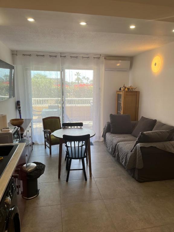 un salon avec un canapé et une table dans l'établissement Hyères Port studio HYERES PARK, à Hyères