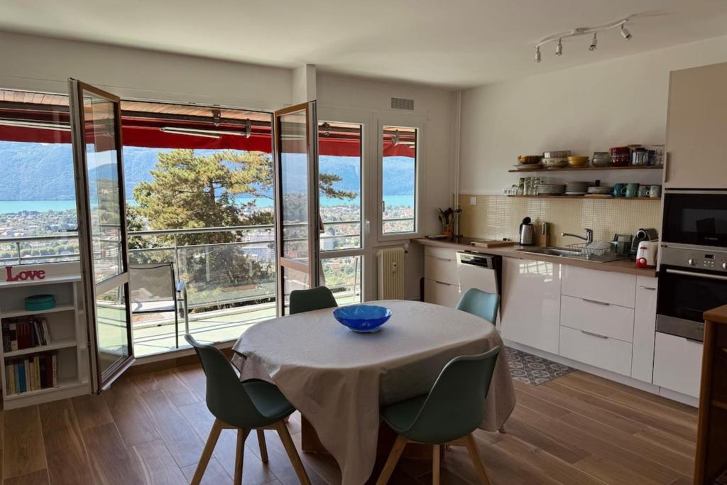 Il comprend une cuisine avec une table et des chaises. dans l'établissement Bright 50m apartment with magnificent lake view, à Aix-les-Bains