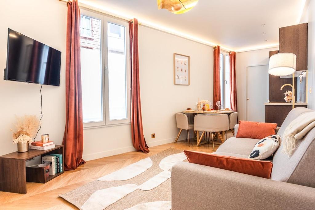 un salon avec un canapé et une table dans l'établissement Appartement d'exception avec Jacuzzi et AC - 6P, à Paris