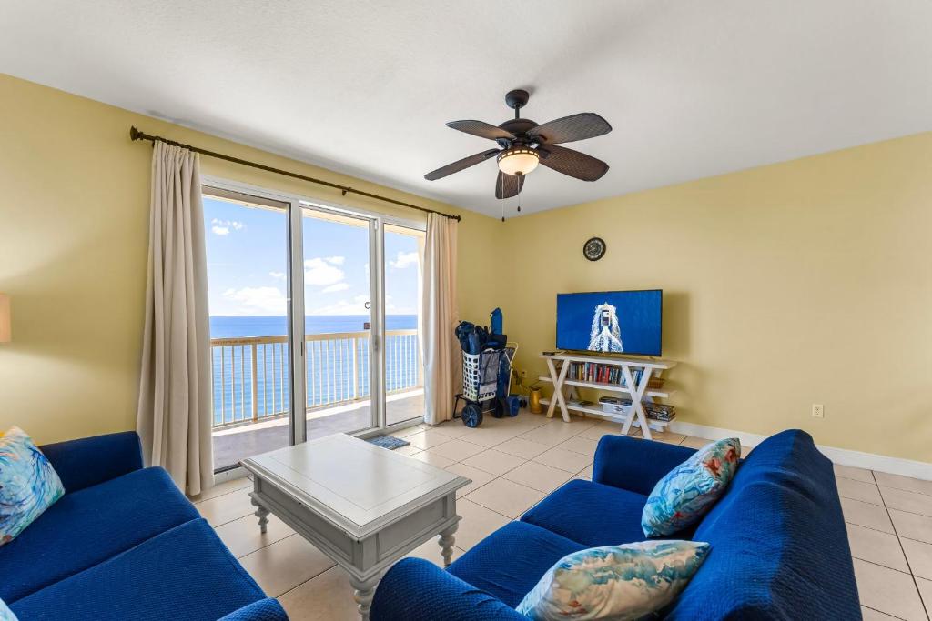 un soggiorno con divano blu e vista sull'oceano di Celadon #2007 a Panama City Beach
