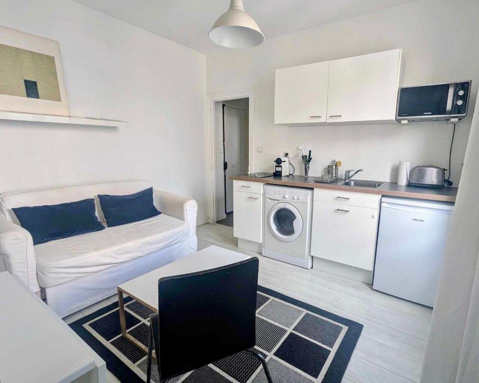 un salon avec un canapé et une cuisine dans l'établissement Moderne appart central 2 personnes, à Paris