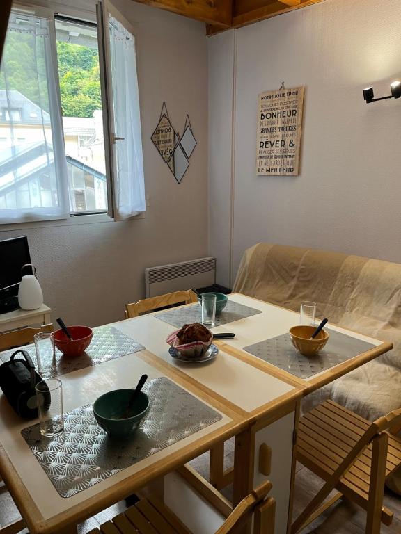 - une table avec des bols dans le salon dans l'établissement Charmant duplex en plein centre de Cauterets de 4 à 6 couchages et 2 chambres dont une sous-toit, à Cauterets