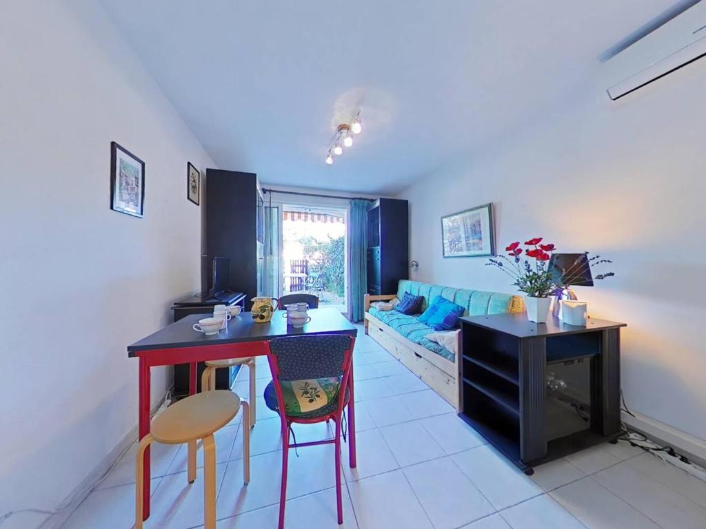 un salon avec une table, des chaises et un canapé dans l'établissement Appartement 2 pièces avec terrasse et piscine, La Londe-les-Maures - FR-1-826-9, à La Londe-les-Maures