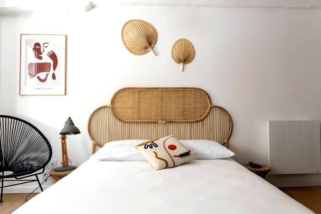 une chambre avec un lit blanc avec une tête de lit en bois dans l'établissement Charmant studio en plein coeur du centre-ville, à Caen